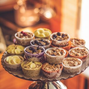 A platter of assorted oatmeal cups, featuring peanut butter banana, chocolate chip, blueberry almond, and pumpkin spice flavors, in a cozy kitchen setting.